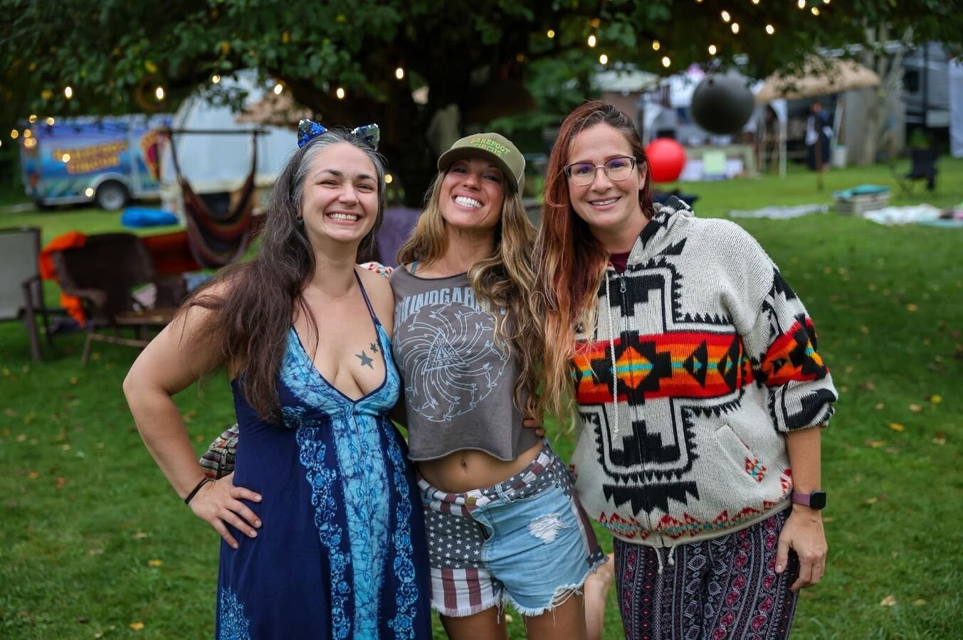 Three friends arm in arm on the lawn at the end of the day