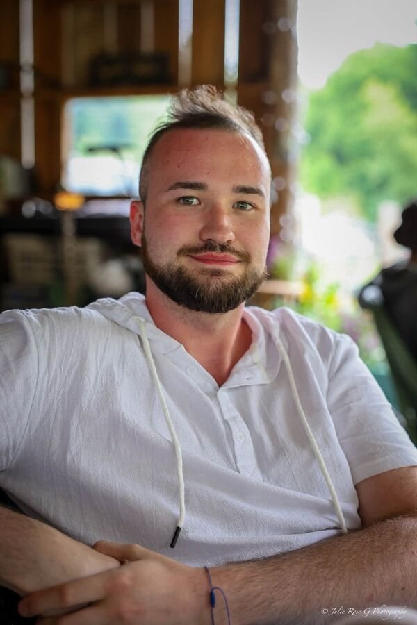 A man in a white shirt sitting in the shade